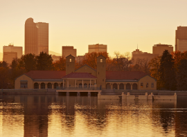 city park lake and park with the Denver skyline behind in the warm yellow glow of sunset