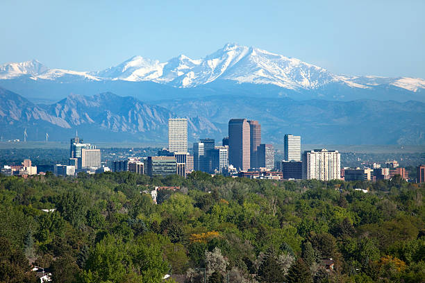 distance shot of the skyline of Denver with the snowcapped mountains in the background