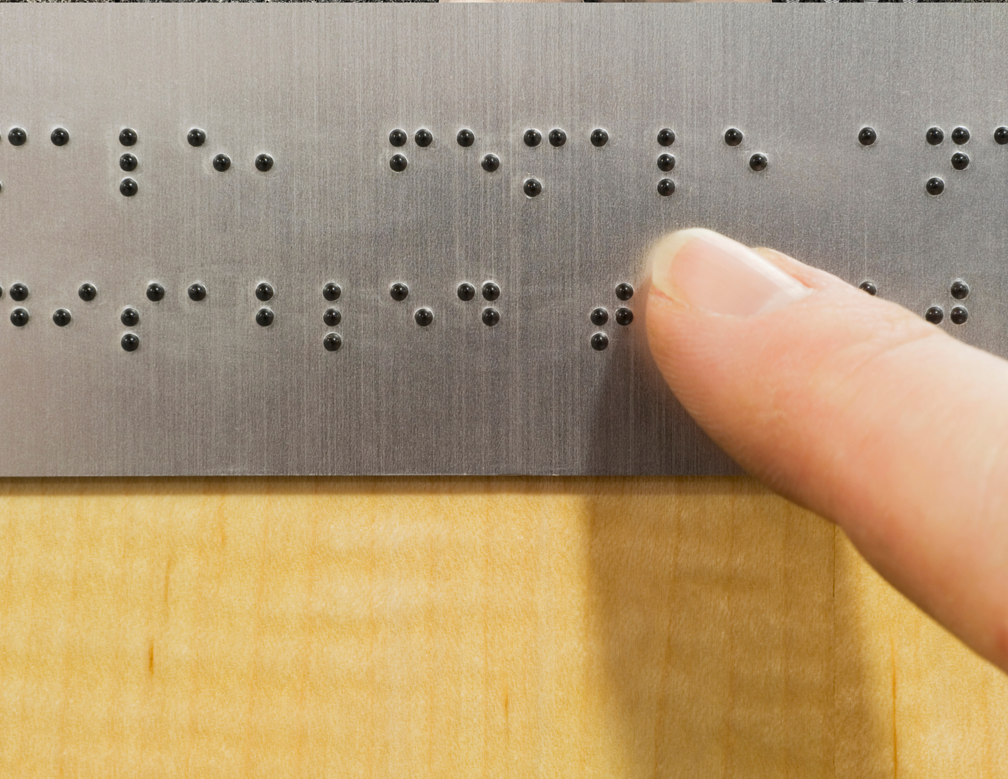 index finger brushing over braille lettering