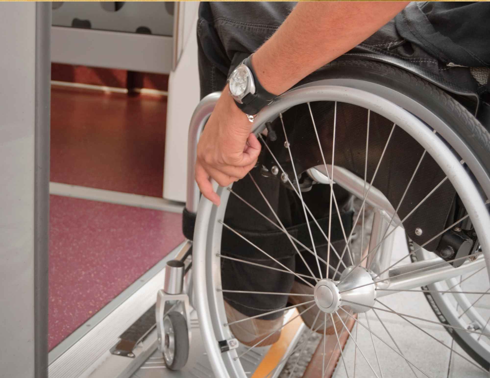 person wearing a watch, sitting in a wheelchair rolling on an evevator